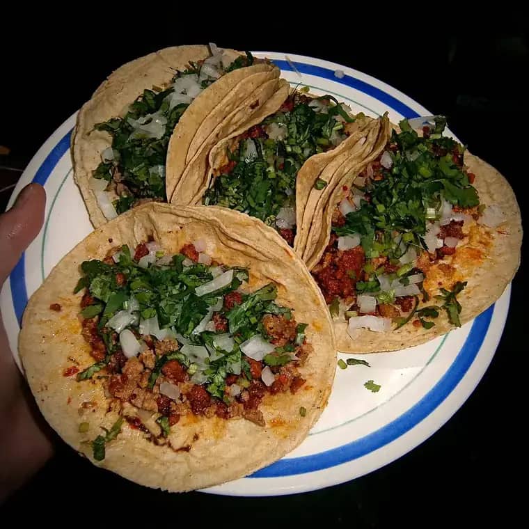 Plato con cuatro tacos campechanos con cebolla y cilantro