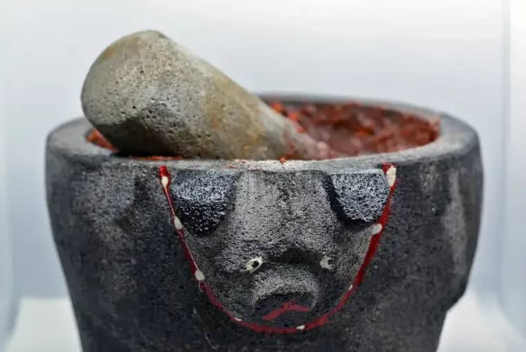 Molcajete de piedra volcánica con salsa roja recién hecha