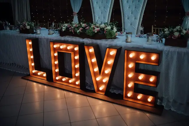 Letras iluminadas frente a la mesa de honor adornada con flores